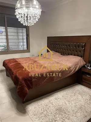 a bedroom with a bed with a real estate sign on it at Furnished apartment in Abdoun in Amman