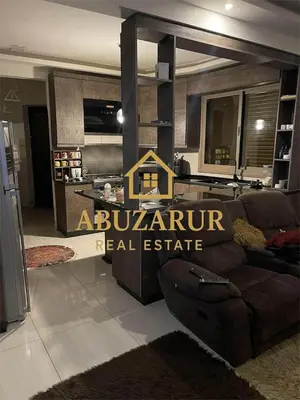 a living room with a couch and a kitchen at Furnished apartment in Abdoun in Amman