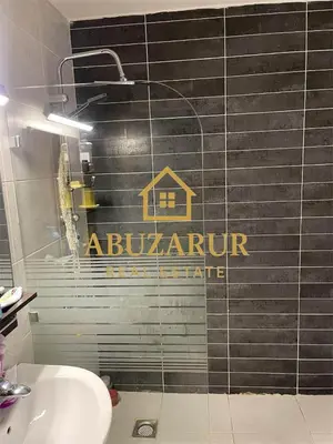 a bathroom with a sign on a tile wall at Furnished apartment in Abdoun in Amman