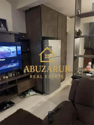 a living room with a tv and a couch at Furnished apartment in Abdoun in Amman
