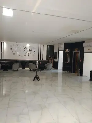 a large lobby with a table in the middle of a room at Power Stay Hotel in Amman