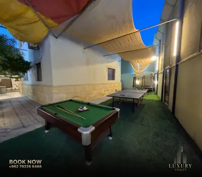 a room with a pool table in a building at Farm Luxury in Shūnat Nimrīn