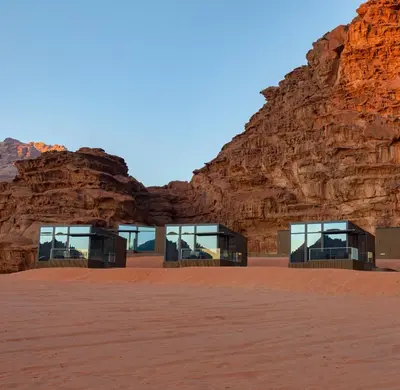 a building in the desert with a rock wall at Rum Reserve Resort-By Luxotel in Wadi Rum