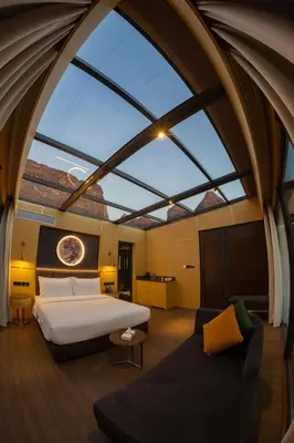a bedroom with a large bed and a large window at Rum Reserve Resort-By Luxotel in Wadi Rum