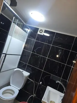 a black tiled bathroom with a toilet and a sink at Studio 3 Cozy Amman Central Near Rainbow Street & First Circle in Amman