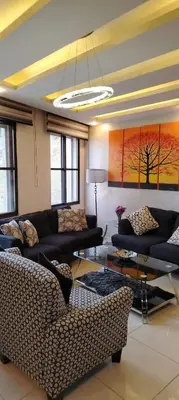 a living room with couches and a table at شقة مفروشة للإيجار بالرابية بالقرب من السفارة الصينية in Amman