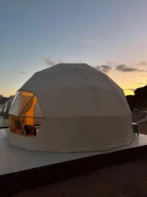 a tent sitting on top of a building with the sunset at Ahmad Wadi Rum Camp in Wadi Rum