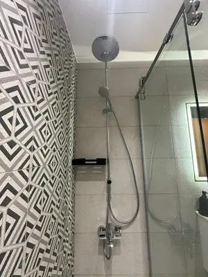 a bathroom with a shower with a wall at Damac Amman Modern Luxury Apartment in Amman