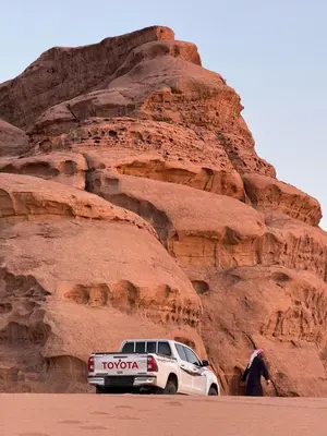 a white truck parked in front of a mountain at Jorye Rum luxure cam in Wadi Rum