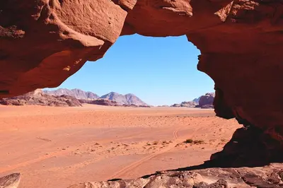a view of the desert through a rock formation at Jorye Rum luxure cam in Wadi Rum