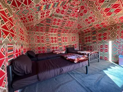 a bedroom with a bed in a room with colorful walls at Wadi Rum Bedouin in Wadi Rum