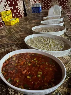 a row of bowls of food on a table at Wadi Rum Bedouin in Wadi Rum