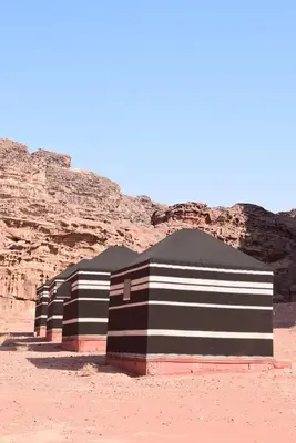 a row of tents in the desert near a mountain at Nature rum camp in Wadi Rum