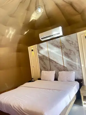 a bed in a room with a ceiling at Wadi Rum Al-Hadi camp in Disah