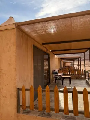 a porch of a house with a wooden fence at Wadi Rum Al-Hadi camp in Disah