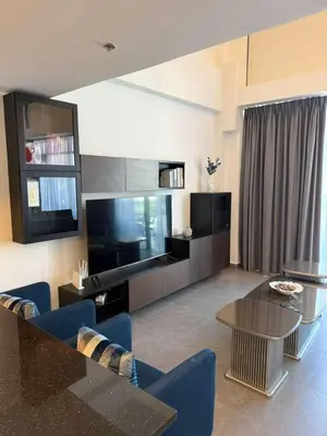 a living room with a television and a table and chairs at DAMAC AMMAN LUXURY APARTMENTs داماك عمان شقق فاخرة in Amman
