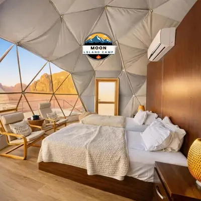 a bedroom with a tent with a bed and chairs at MOON ISLAND lUXURY CAMP in Wadi Rum