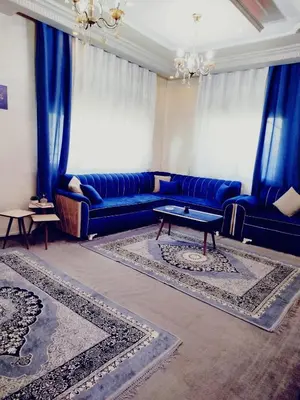 a living room with blue couches and blue curtains at طبربور in Amman