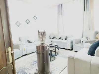 a living room with white couches and a lamp in the middle at طبربور in Amman