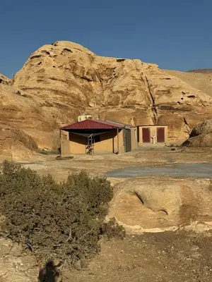 a small building in front of a mountain at Bedouin Family Camp in Al Ḩayy