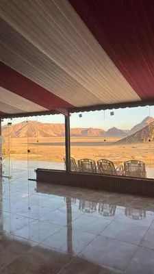 a group of chairs sitting in a building with a view of the desert at Wadi Ram camp in Disah