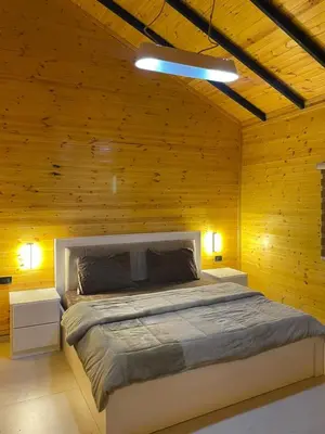 a bedroom with a large bed in a wooden wall at شاليه غصن in Ajloun