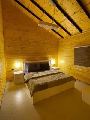 a bedroom with a bed in a wooden wall at شاليه غصن in Ajloun