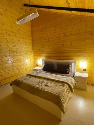 a bedroom with a large bed in a wooden wall at شاليه غصن in Ajloun