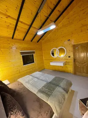a bedroom with a large bed in a wooden room at شاليه غصن in Ajloun