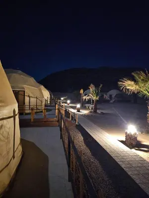 a group of tents on a beach at night at Amjad Rum Camp in Disah