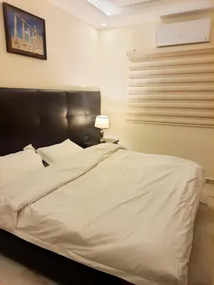 a white bed with a black headboard in a bedroom at I cloud Petra hostel in Wadi Musa