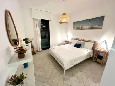 a bedroom with a white bed and a mirror at Ayla in Aqaba