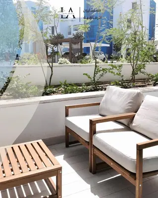 two wooden chairs and a bench on a balcony at Ayla in Aqaba