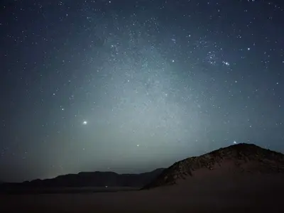 a starry night with the milky way over a mountain at Tariq Camp Wadi Rum in Wadi Rum