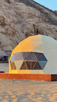 a yellow and white building in the middle of a desert at Tariq Camp Wadi Rum in Wadi Rum