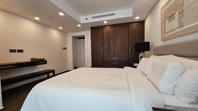 a bedroom with a large white bed and a desk at Luxury 2-BR Apartment Abdali Boulevard Family in Al Jafr