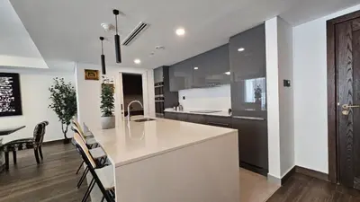 a kitchen with a white counter and a dining room at Luxury 2-BR Apartment Abdali Boulevard Family in Al Jafr