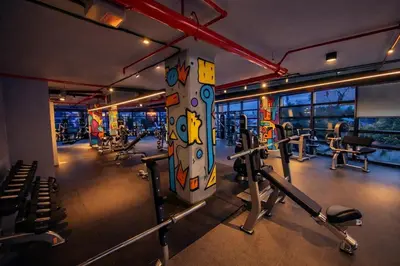 a gym with several treadmills and machines at Gampbell Gray Elite Abdali Apartment in Amman