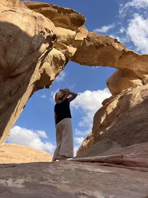 a man standing in front of a rock formation at Wadi Rum Tours and Camp in Wadi Rum