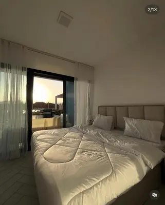 a large white bed in a bedroom with a window at Seaside Luxury Apartment with Terrace and BBQ in Aqaba