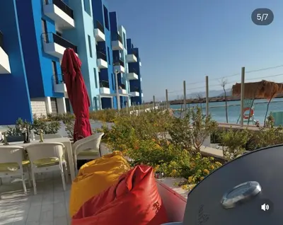 a patio with a table and chairs and a building at Seaside Luxury Apartment with Terrace and BBQ in Aqaba
