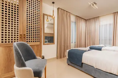 a bedroom with a bed and a chair at Golden Pillar Hotel in Aqaba