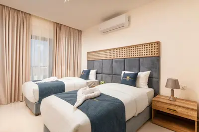 a hotel room with two beds and a window at Golden Pillar Hotel in Aqaba
