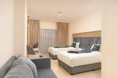 a hotel room with two beds and a couch at Golden Pillar Hotel in Aqaba