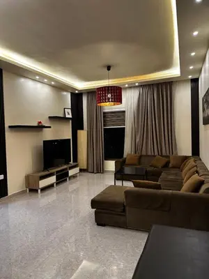 a living room with a couch and a television at شقة بالرابية in Amman