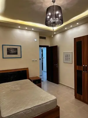 a bedroom with a bed and a chandelier at شقة بالرابية in Amman