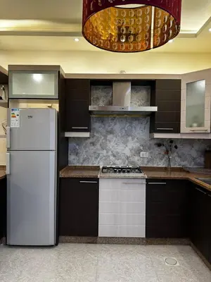 a kitchen with a white refrigerator and a stove at شقة بالرابية in Amman