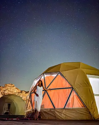 a woman standing in front of a tent at BUBBLES CAMp in Wadi Rum