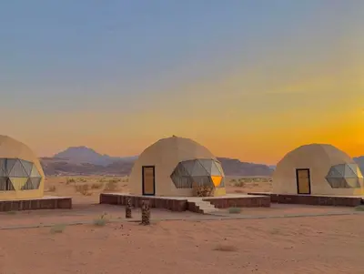 a group of domes in the desert at sunset at Desert Stars Bubble Camp Wadi Rum in Wadi Rum