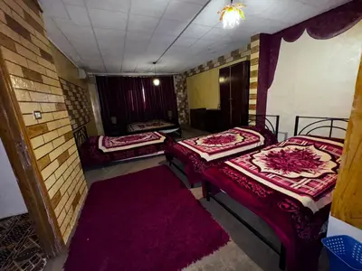 a room with two beds and a red carpet at Rocky Mountain Hotel Jordan in Petra